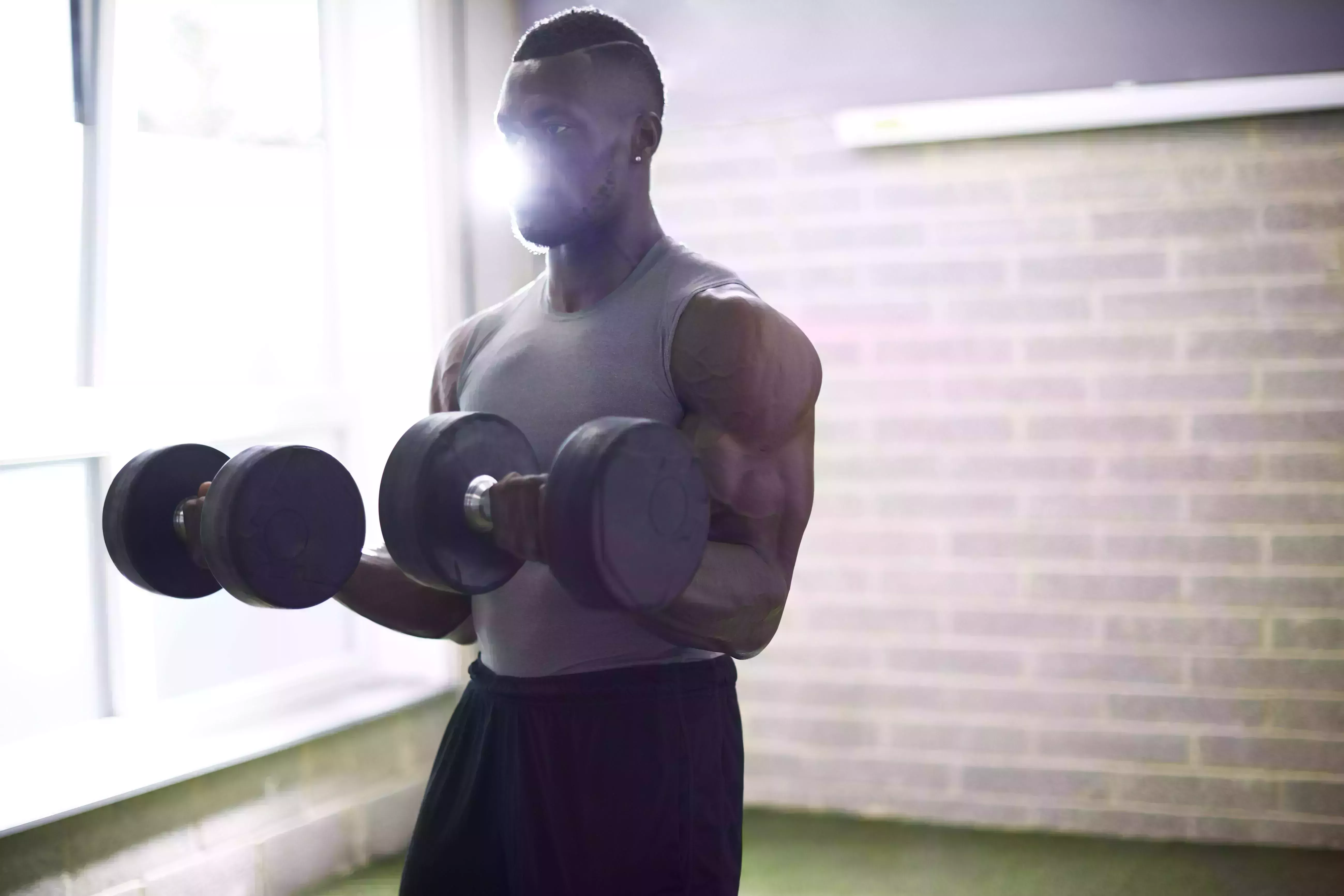 man lifting dumbbells in gym