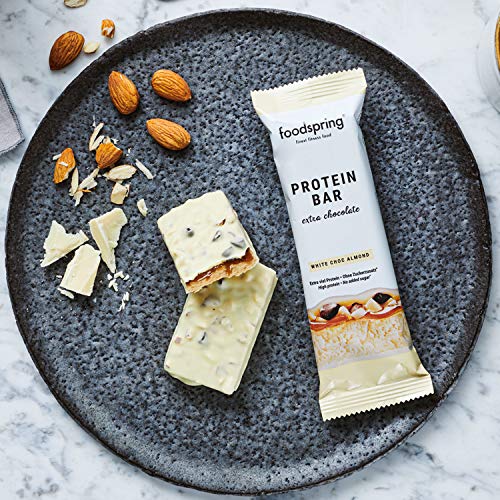 foodspring Barritas De Proteína Extra Choco, Chocolate Blanco y Almendras, 12 x 65g, una auténtica chocolatina con 95% menos de azúcares