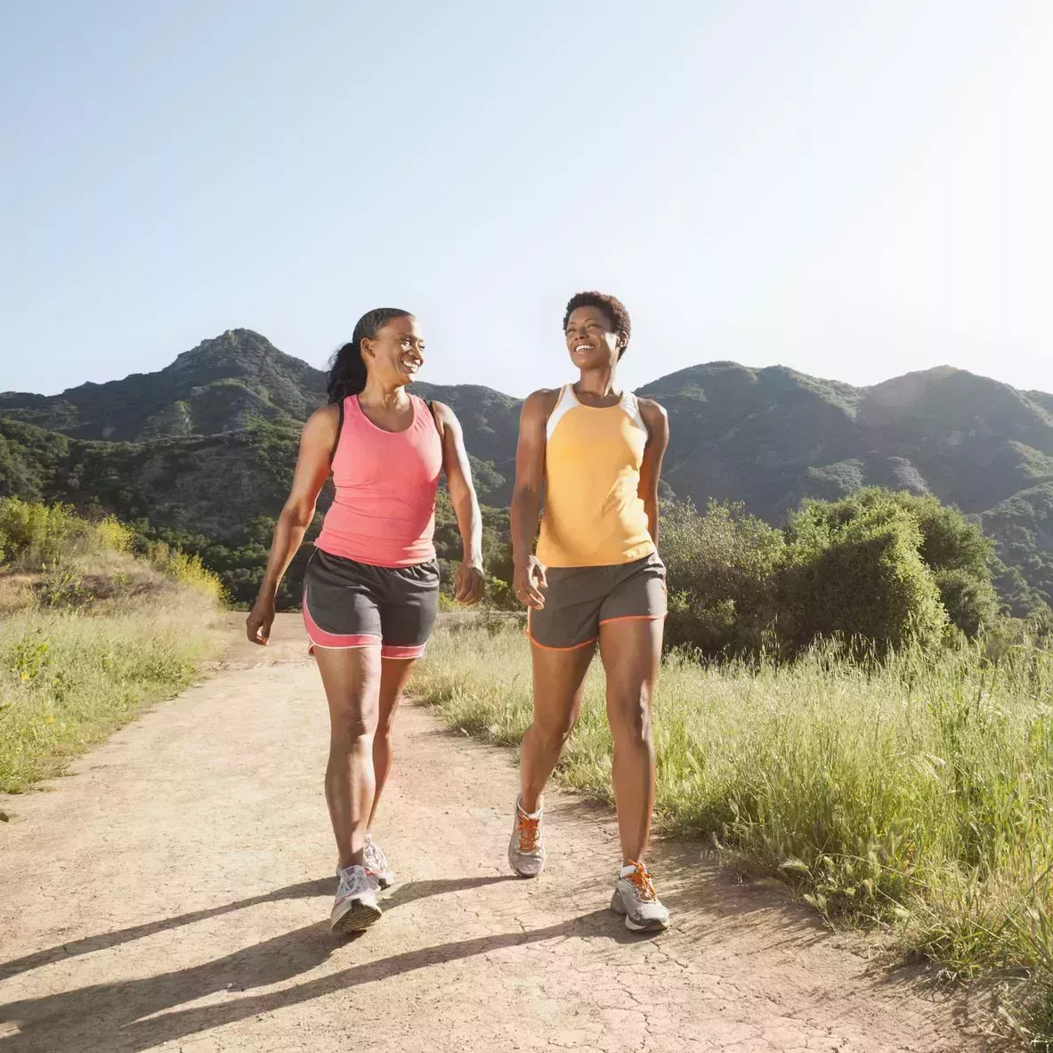 Athletic women walking together on remote trail athletic women walking together on remote trail