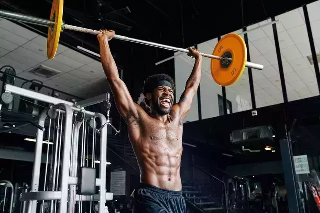 shouting man lifting heavy barbell