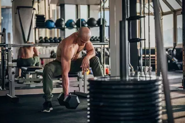 fit man picking up dumbbell