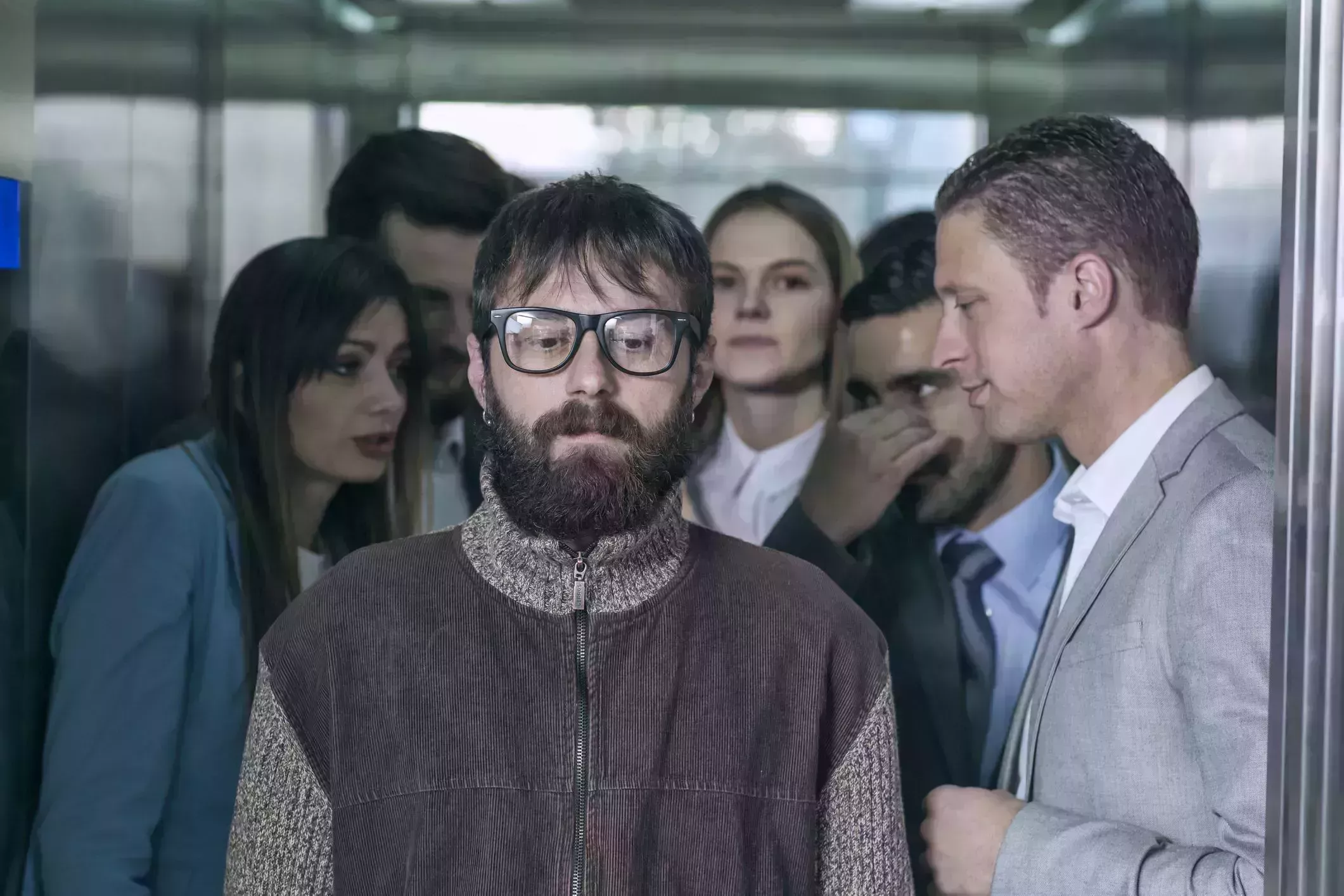 a dirty hipster affecting his coworkers in an elevator