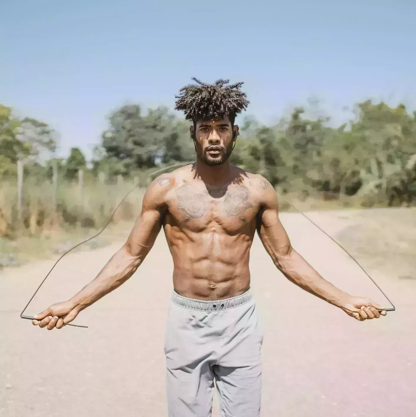 young man skipping rope during workout in a park