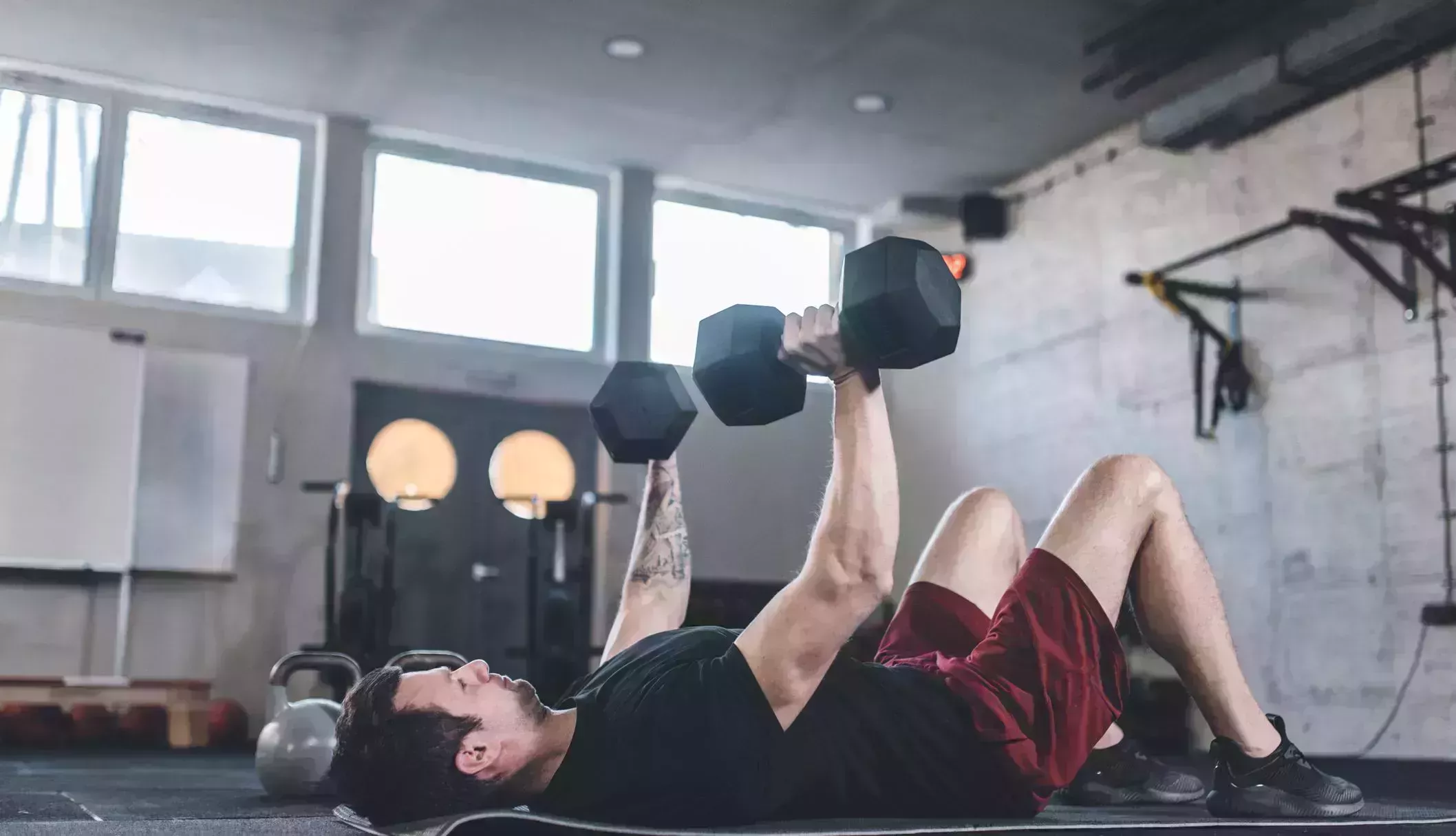 caucasian man doing exercises for the chest using dumbbels