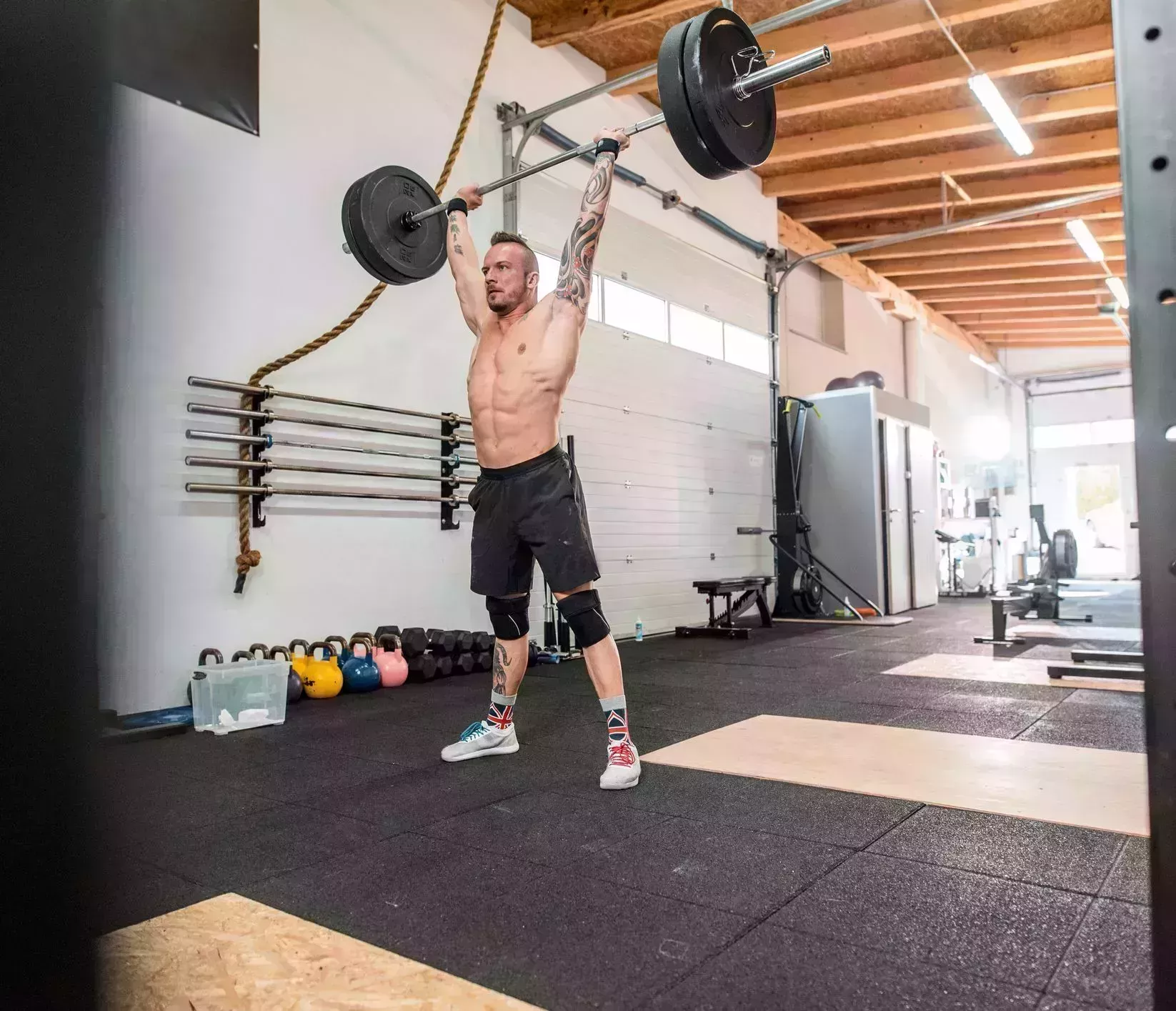 man doing a clean and jerk at the gym