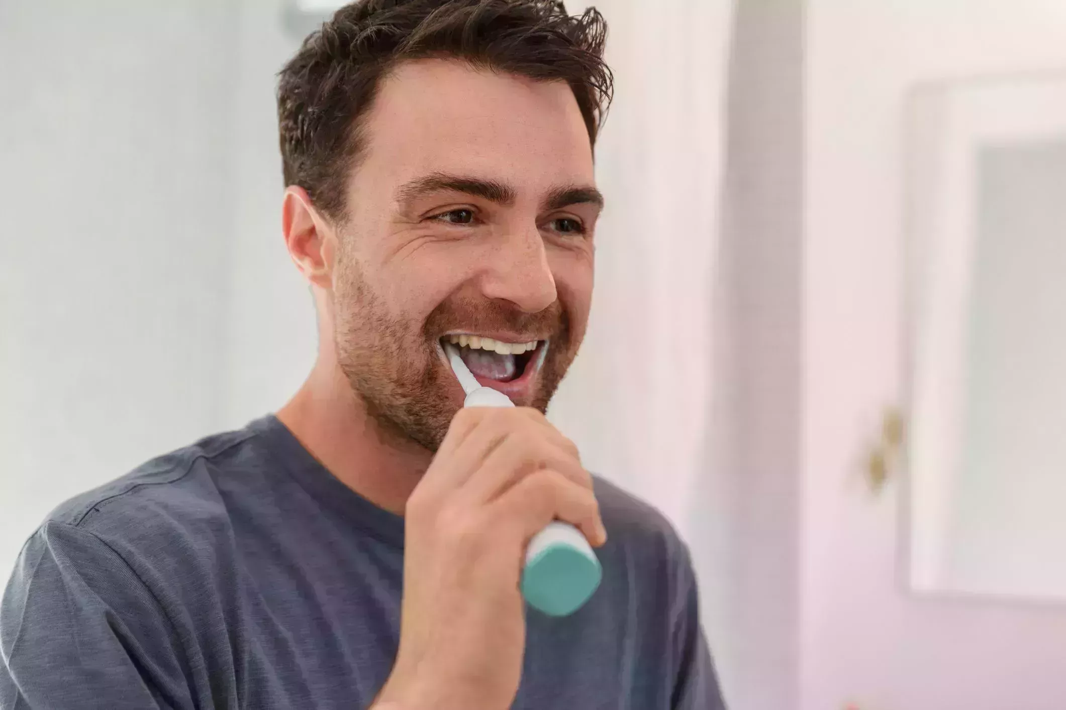 man brushing teeth smiling