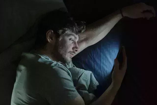 man in bed on smartphone