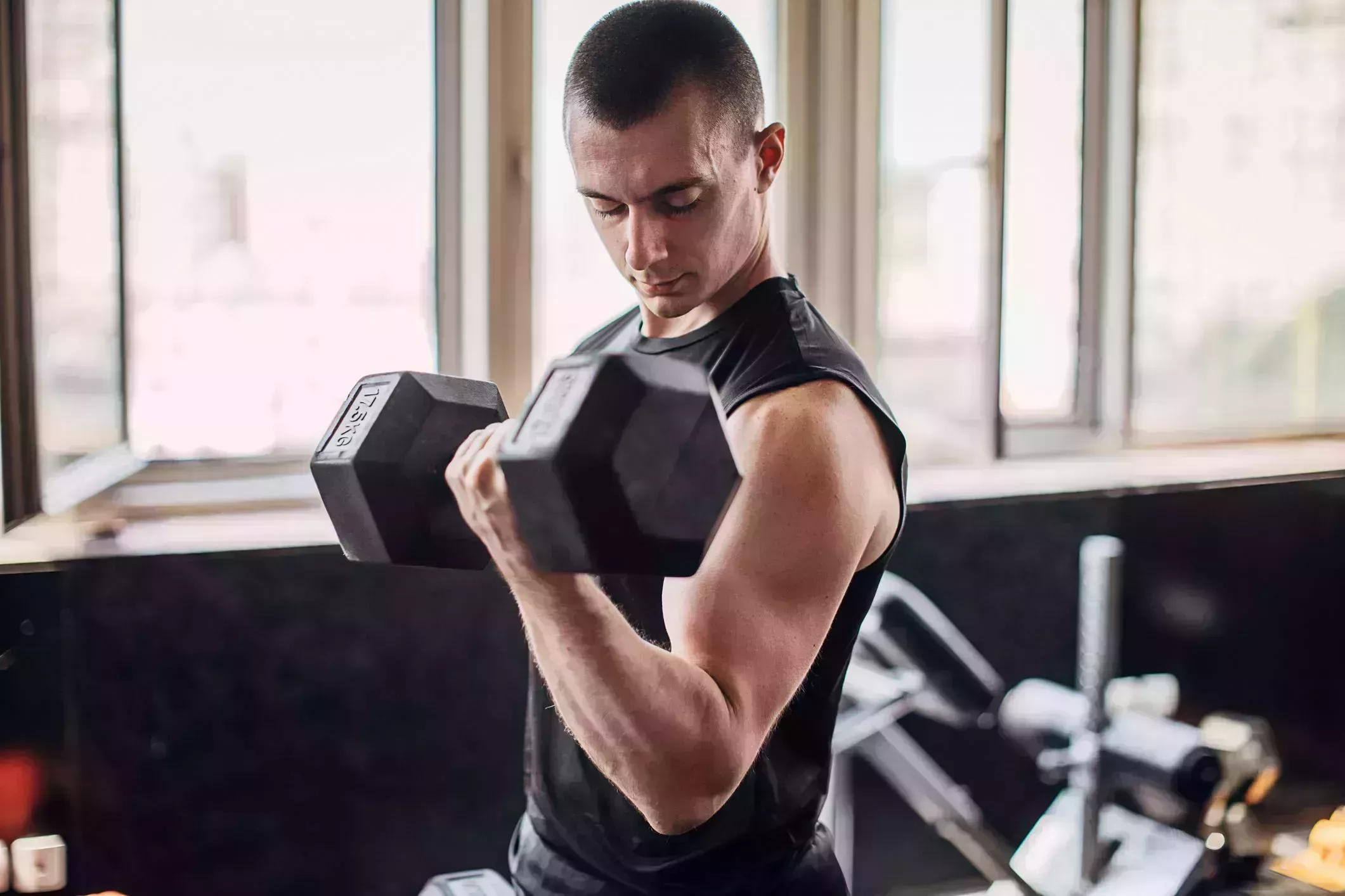 man exercising with dumbbell in gym