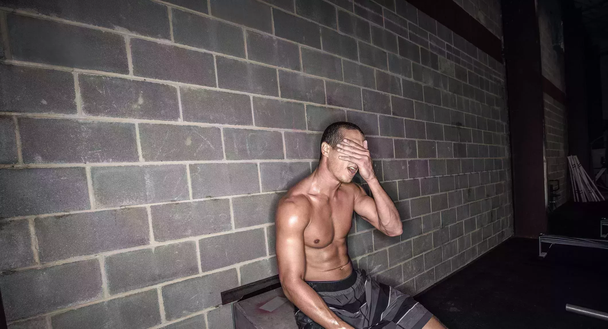 young male athlete sitting having a break in gym