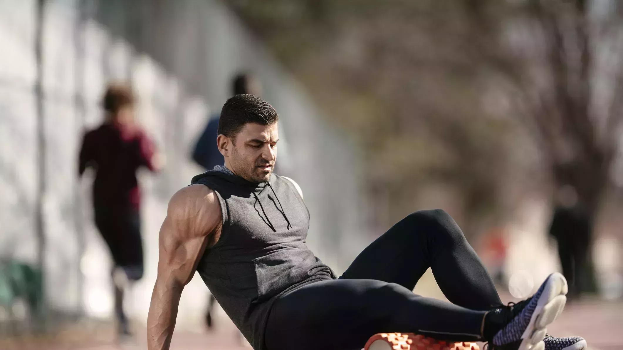 young man stretching himself on a foam roller