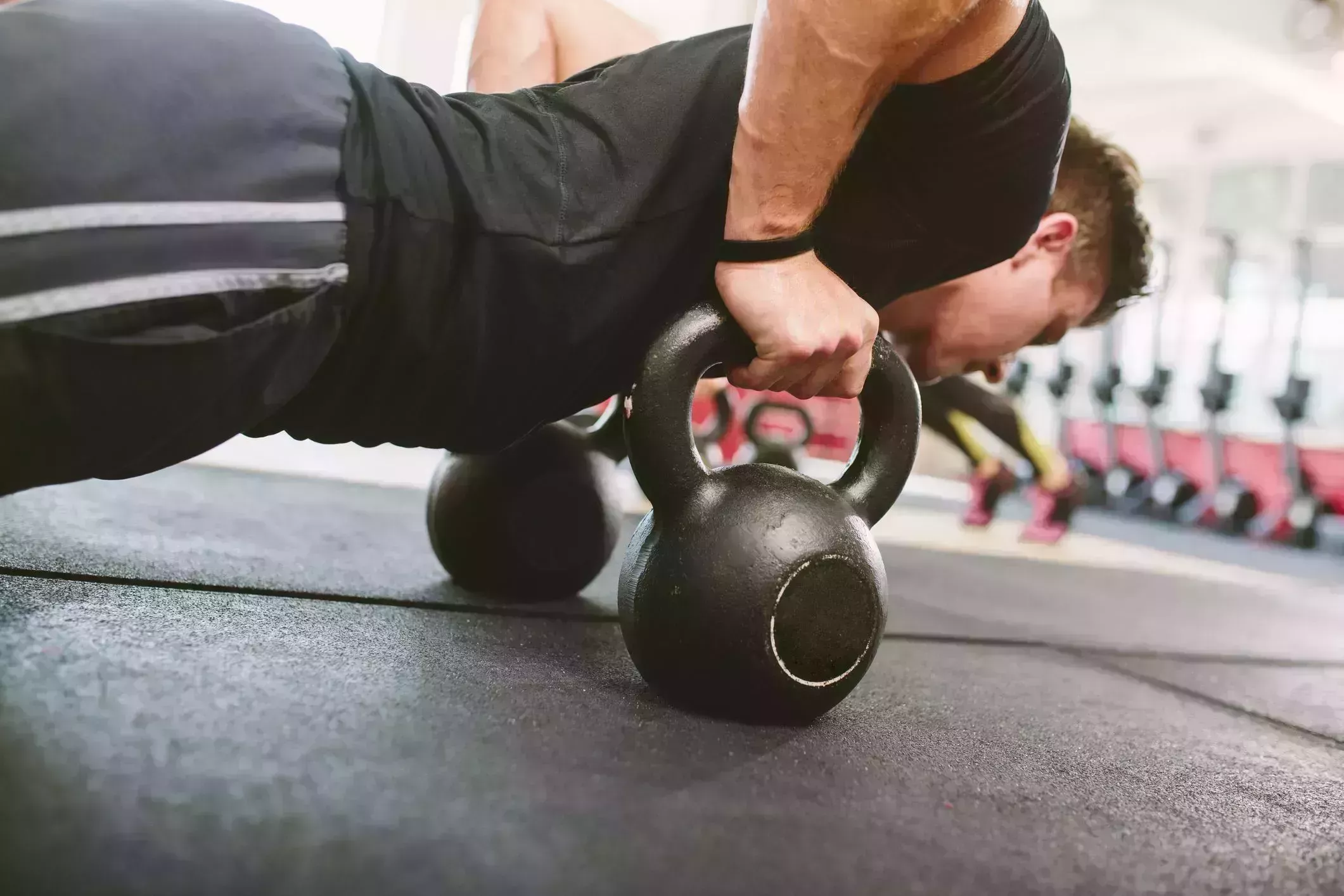 gym athlete doing push ups on kettlebells