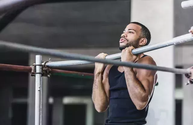 male athlete doing chin ups in a gym