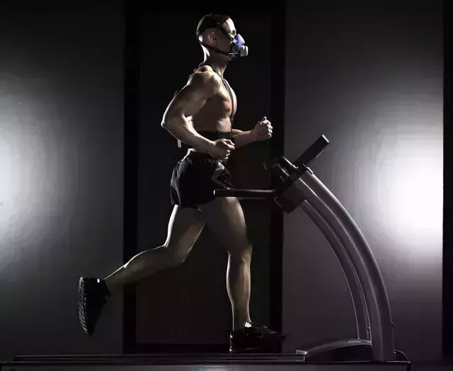 man running on treadmill, wearing oxygen mask, side view