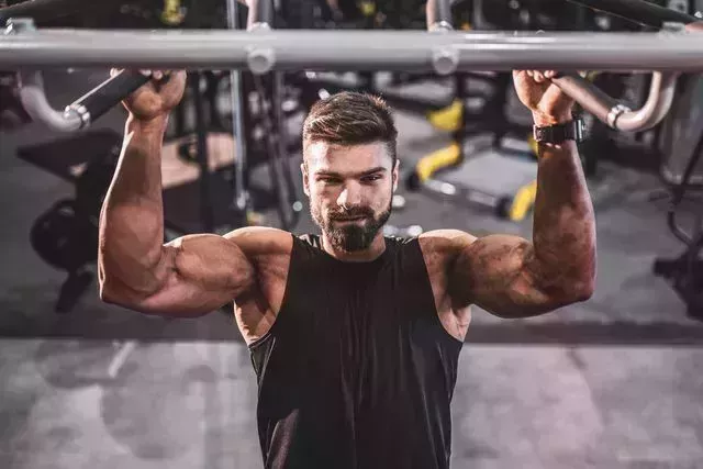 young bodybuilder doing pullups at the gym