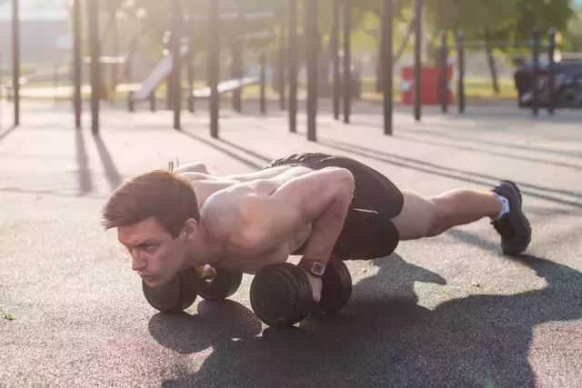 muscular male athlete doing push ups exercises