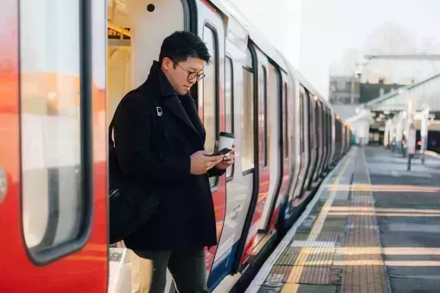 businessman using smart phone on the train platform