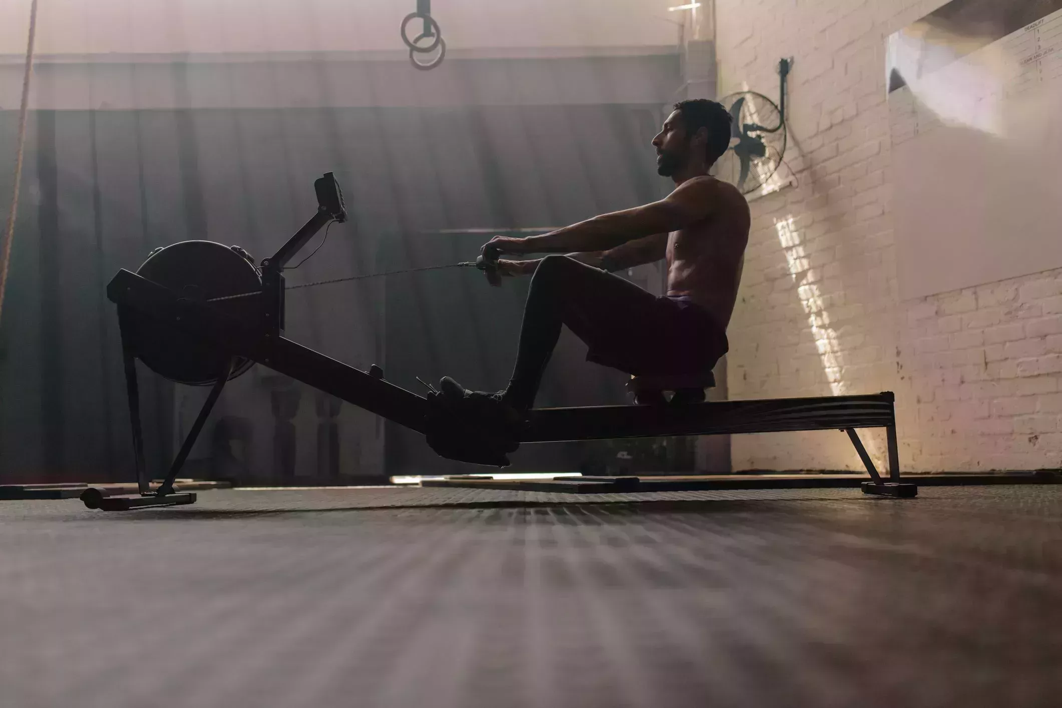 male using rowing machine at fitness club