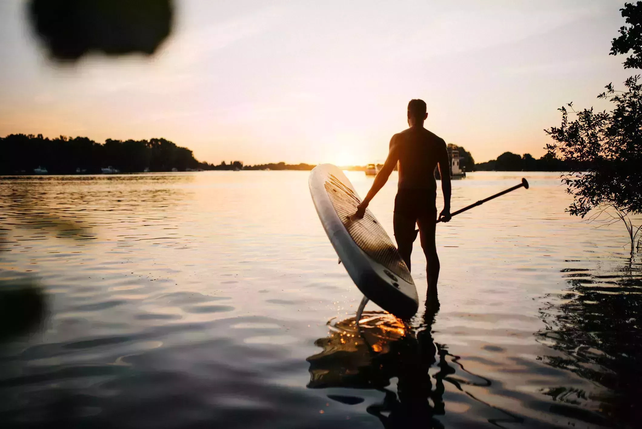 silhouette man standing on lake against sky during sunset