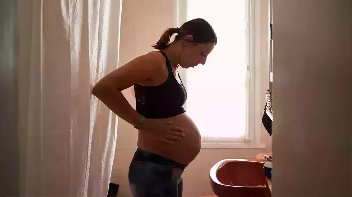 pregnant woman with heart disease looking at her pregnant stomach