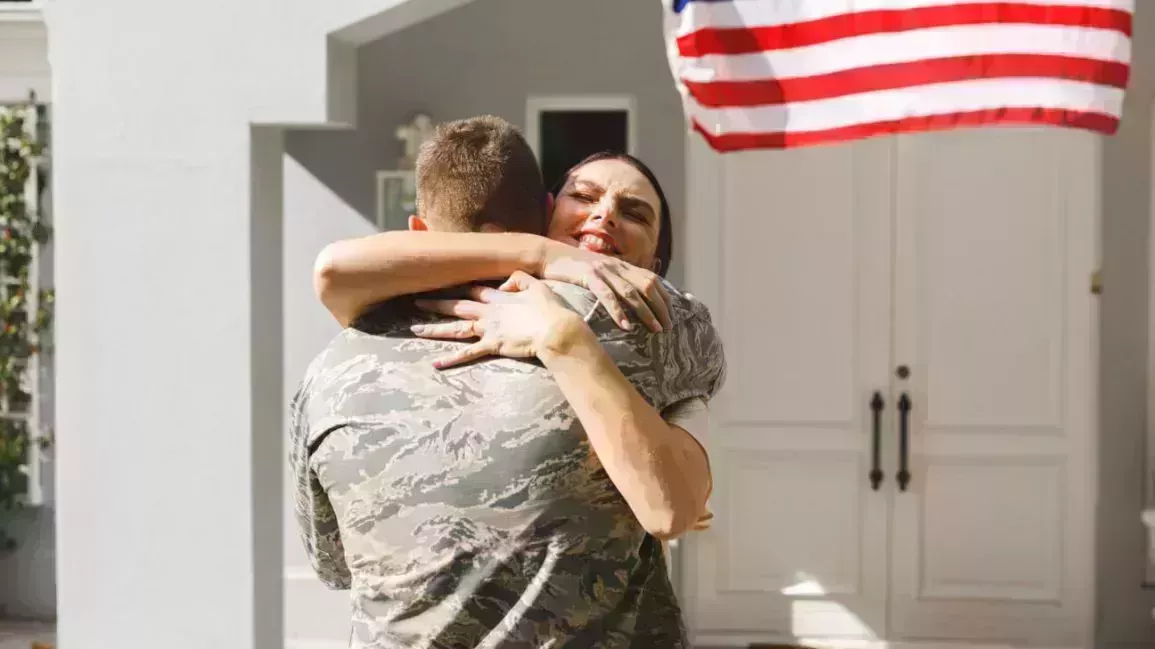 a military service member being embraced by their spouse
