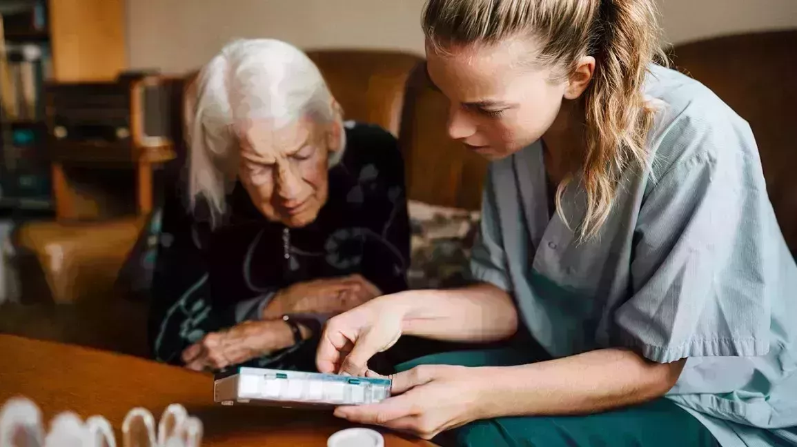 heathcare professional helping older woman organize her dual antiplatelet therapy medication