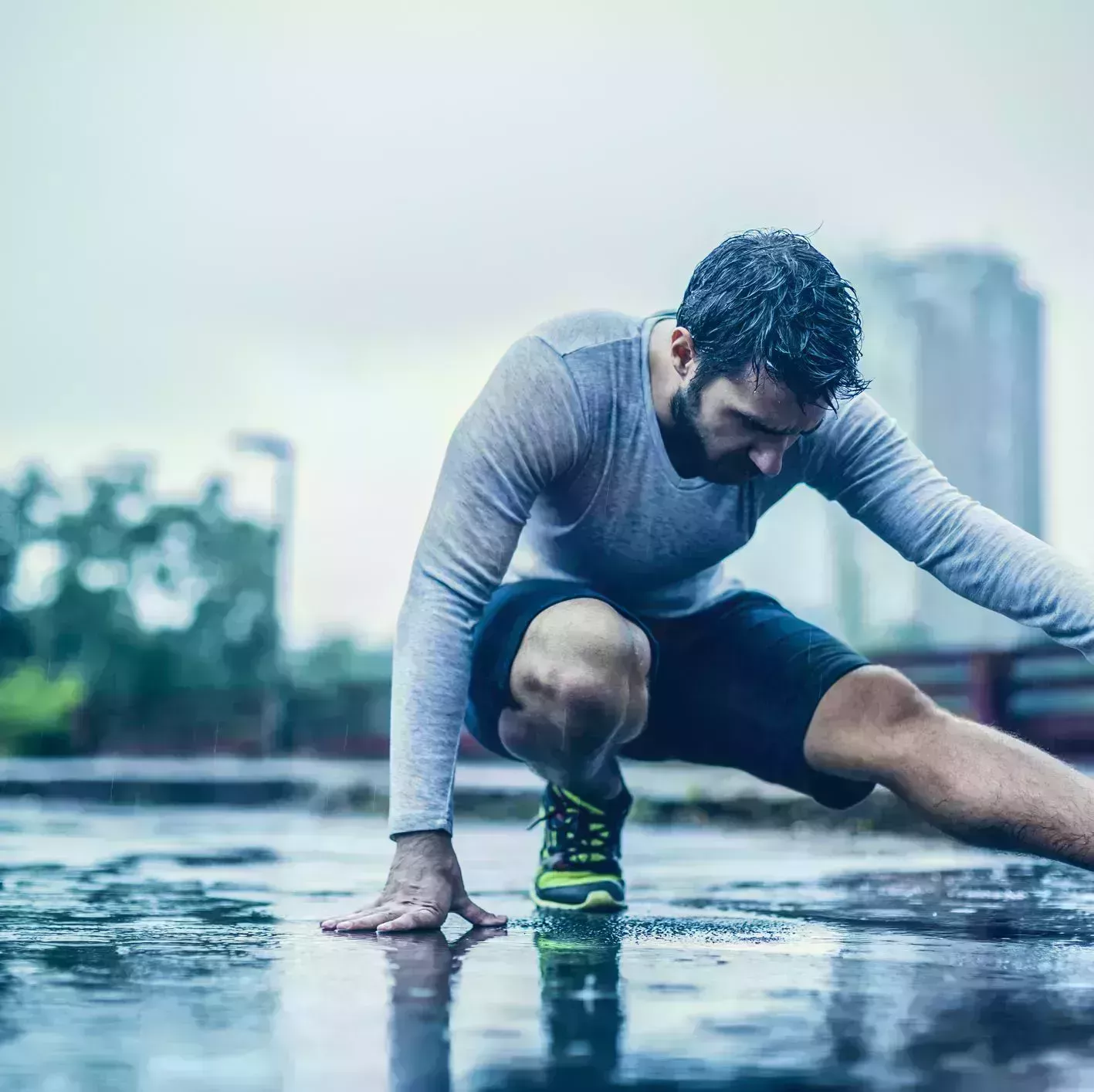 close up of a man stretching in the rain