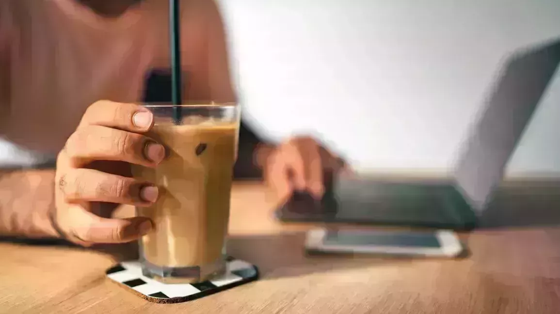 Someone reaching for their iced coffee as they research asthma and cold drinks.