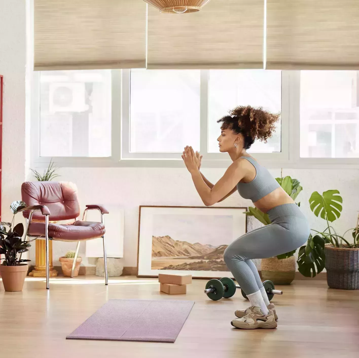 young woman practicing squats in living room