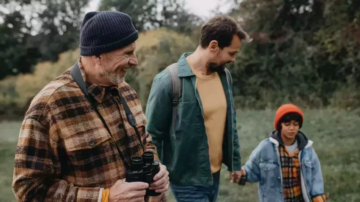 Three generations of men, taking a walk in the woods. 