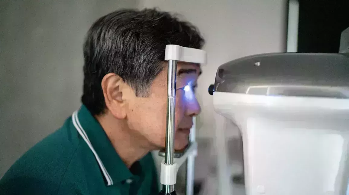 A man gets his eye pressure checked with a tonometry test at the eye doctor's office. 