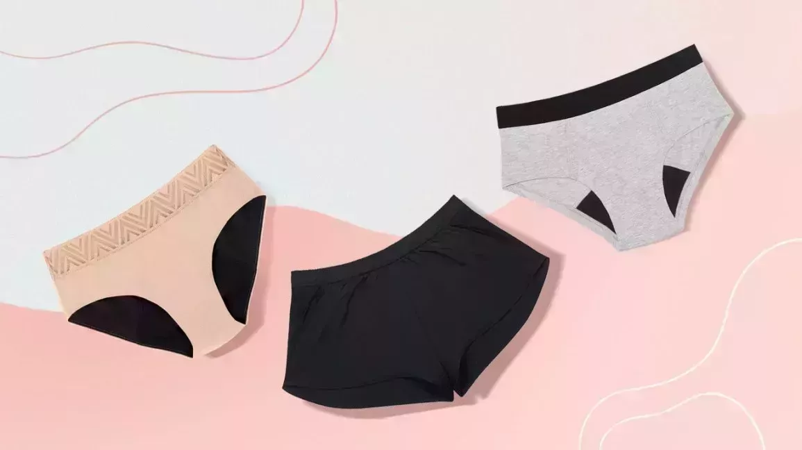 three pairs of absorbent underwear against a pink and white backdrop