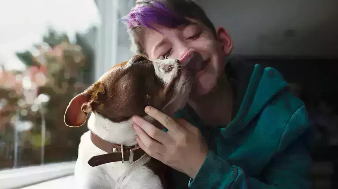 crying child with purple hair hugging dog for comfort