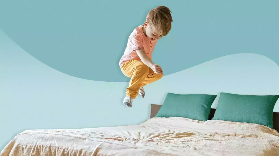 Boy jumping on a bed