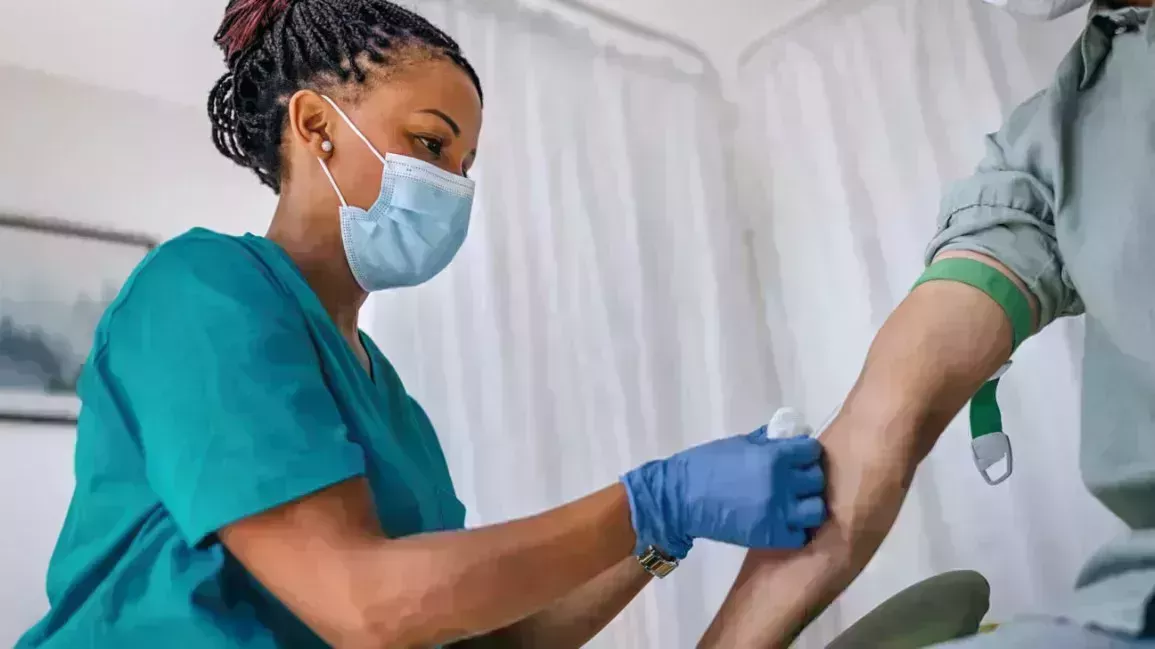 A patient gets their blood drawn by a nurse to determine if they have anemia.