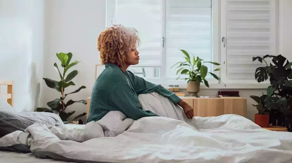 Woman sitting on her bed.