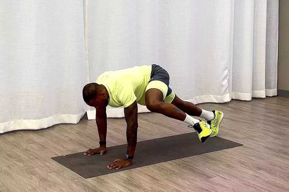 10minute core workout, yusuf jeffers practicing inchworm to plank knee drive exercise