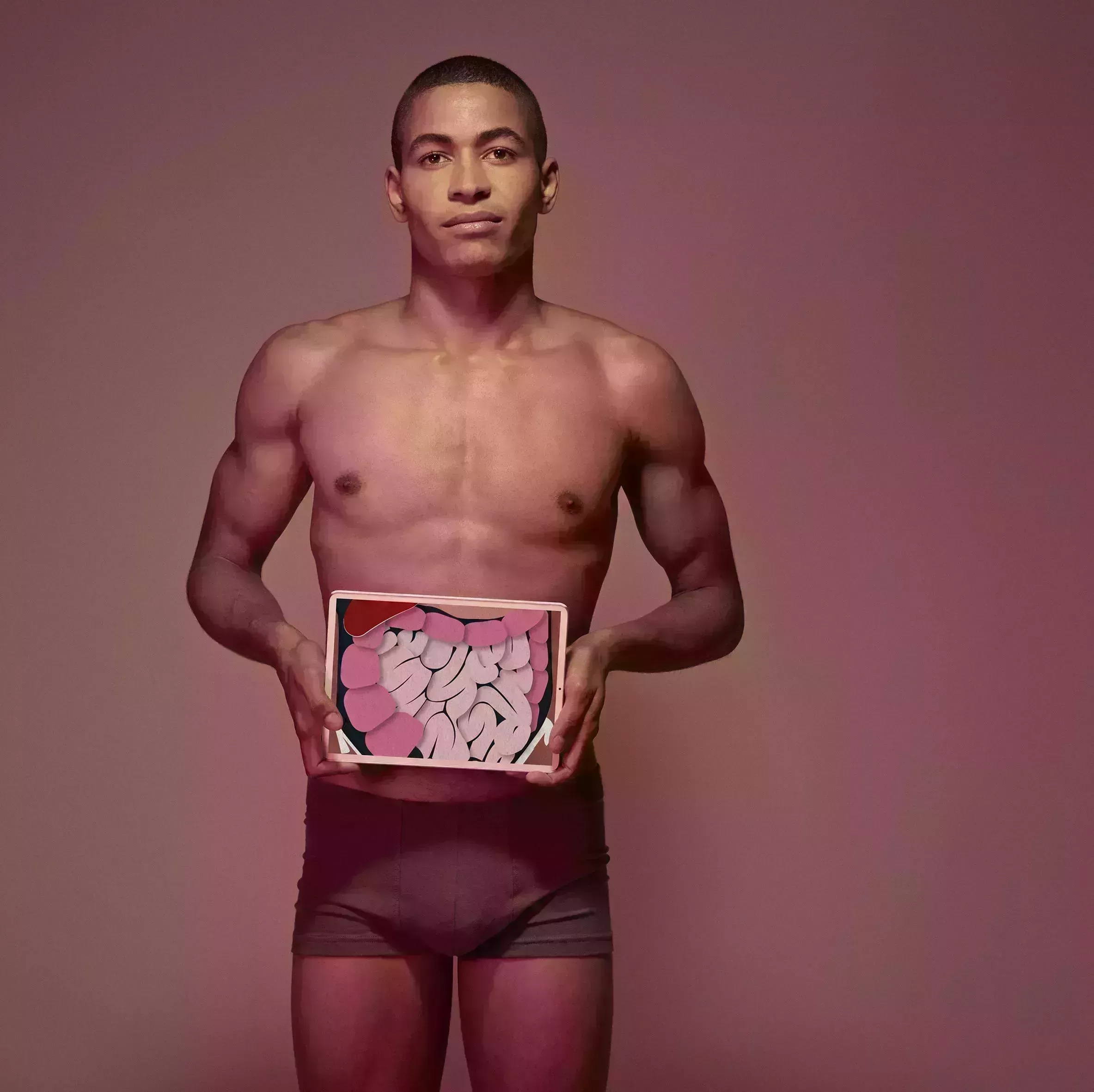 male holding tablet in front of body to display coloured x ray illustrations made out of hand made paper structures