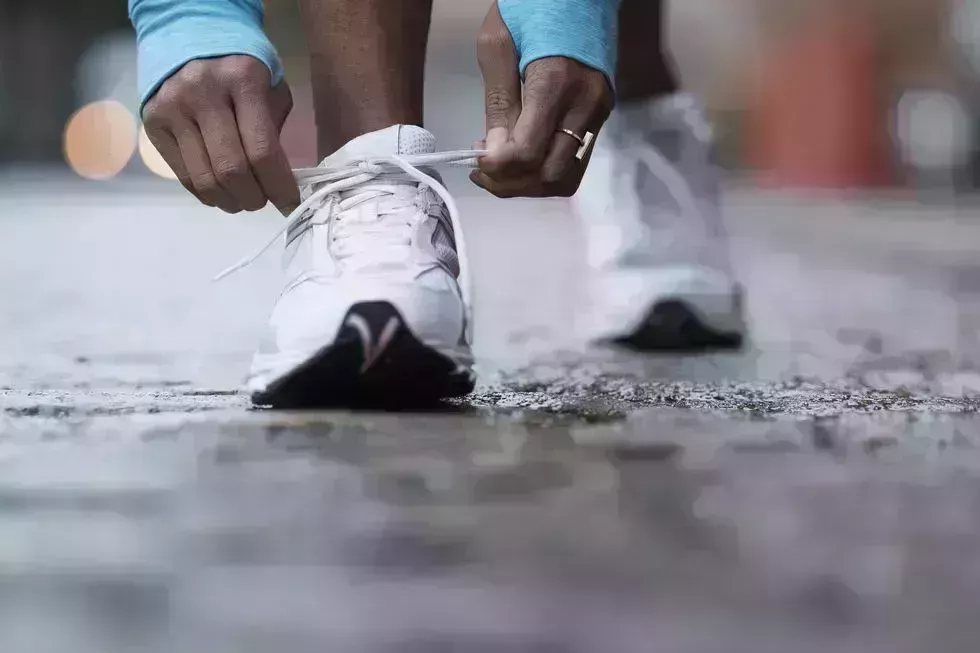 mixed race runner tying shoelaces