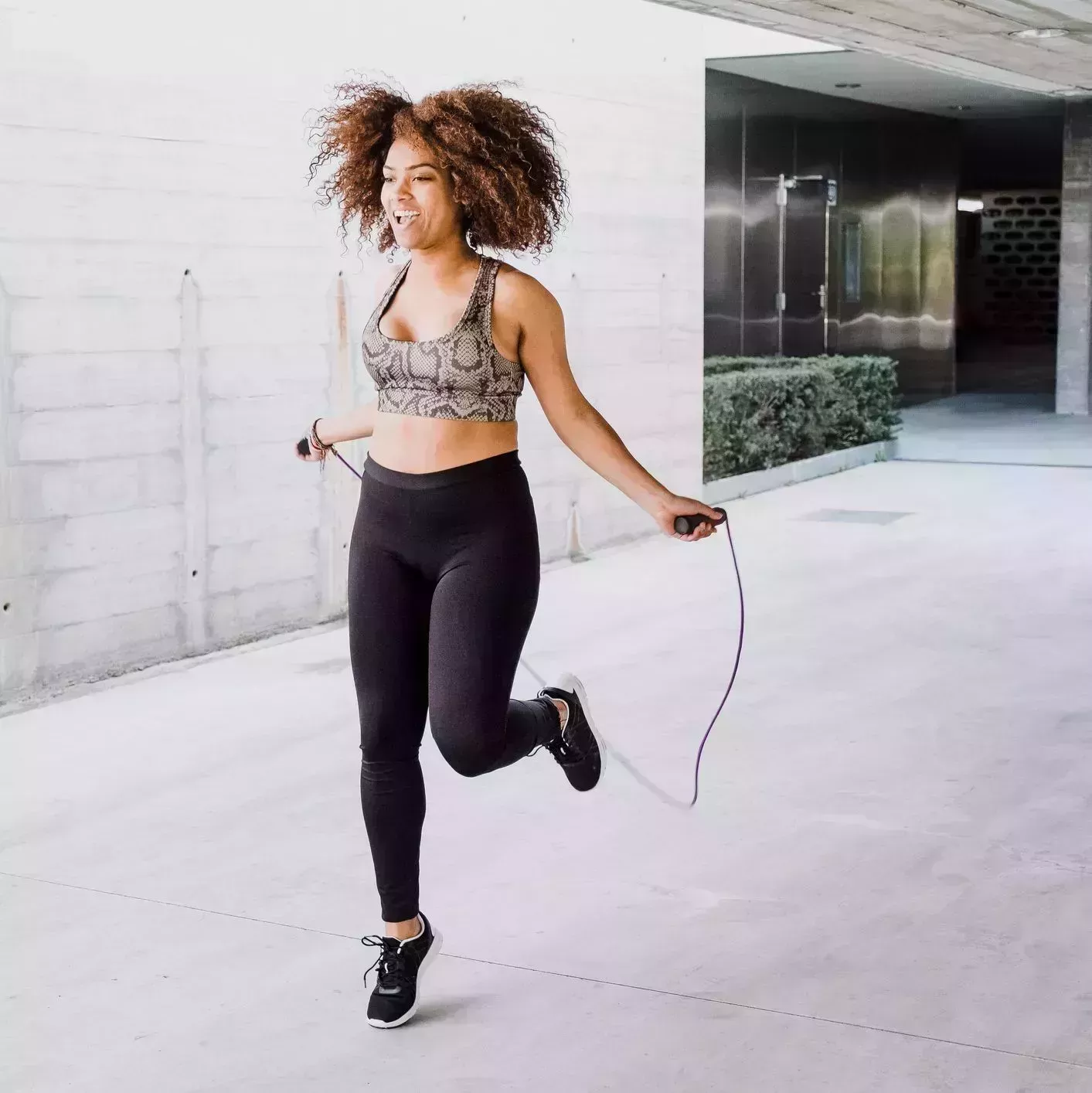 african american woman skipping rope in urban area