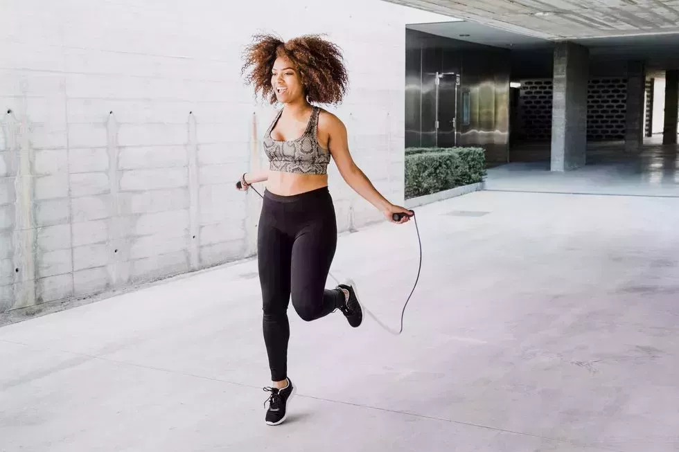 curvy african american woman skipping rope in urban area