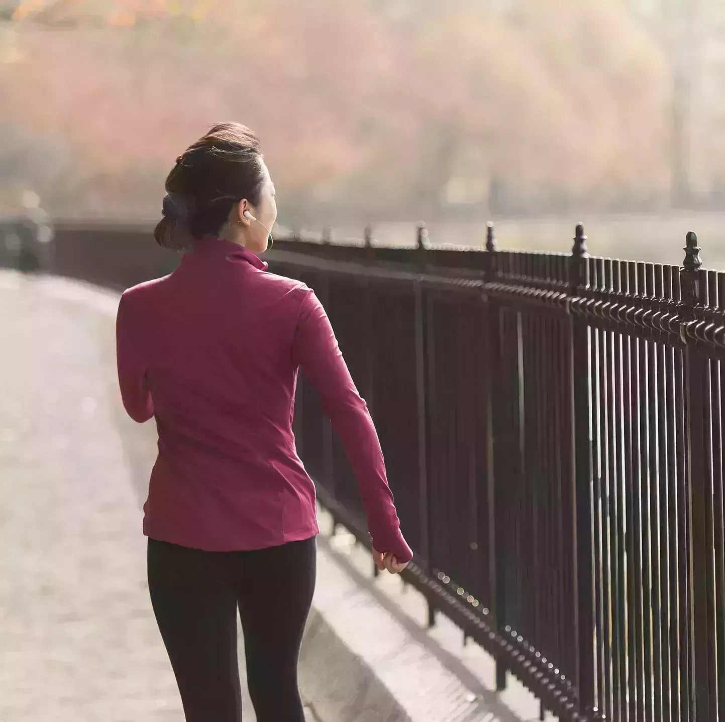 asian woman running on waterfront path