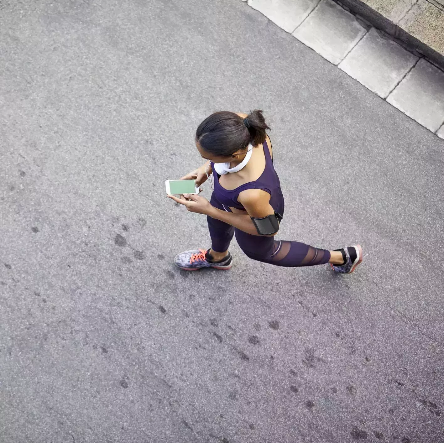 woman using mobile phone while walking on street