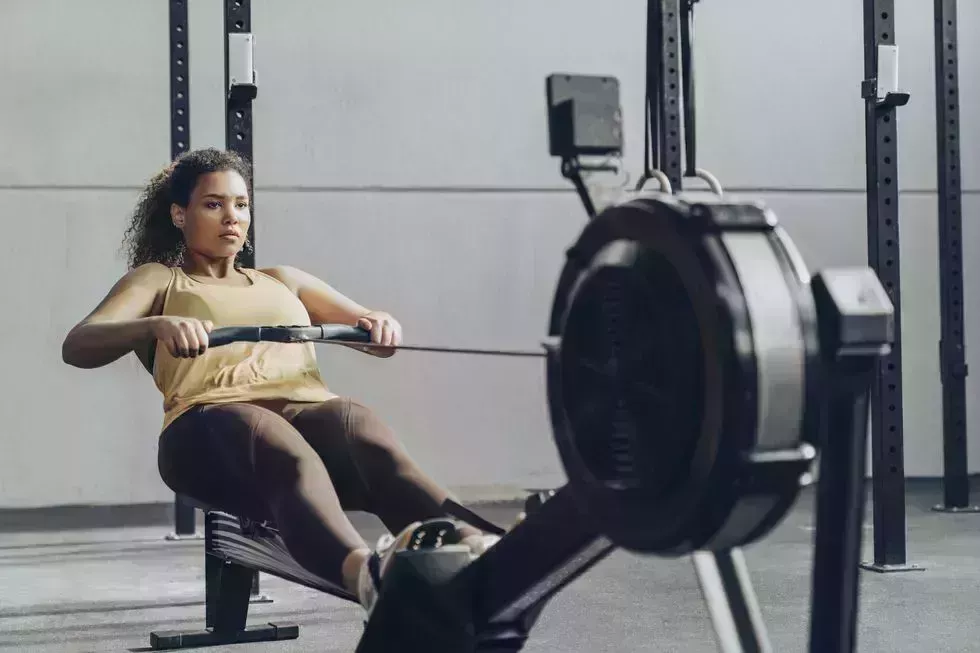 Young woman exercising in gym with rowing machine young woman exercising in gym with rowing machine