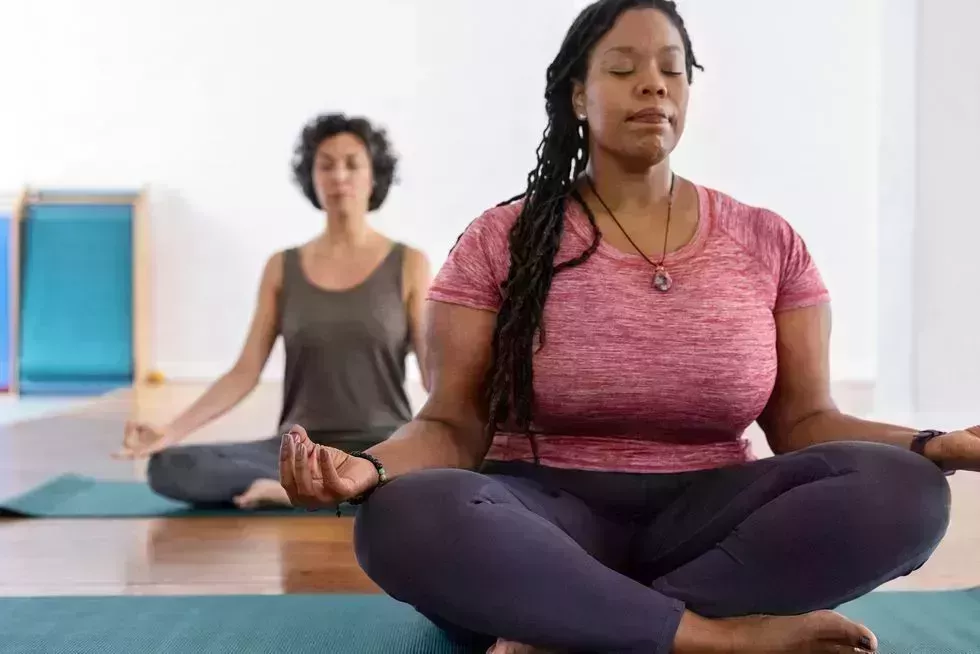 healthy african woman meditating in yoga class