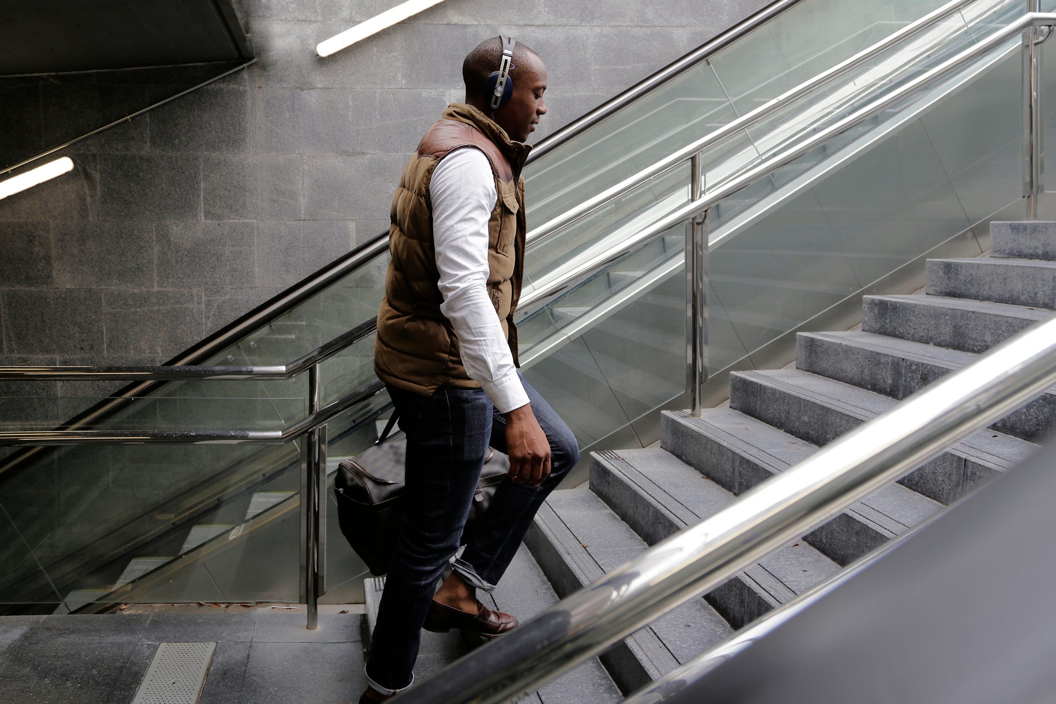 Vista lateral de un hombre subiendo escalones en una estación de metro
