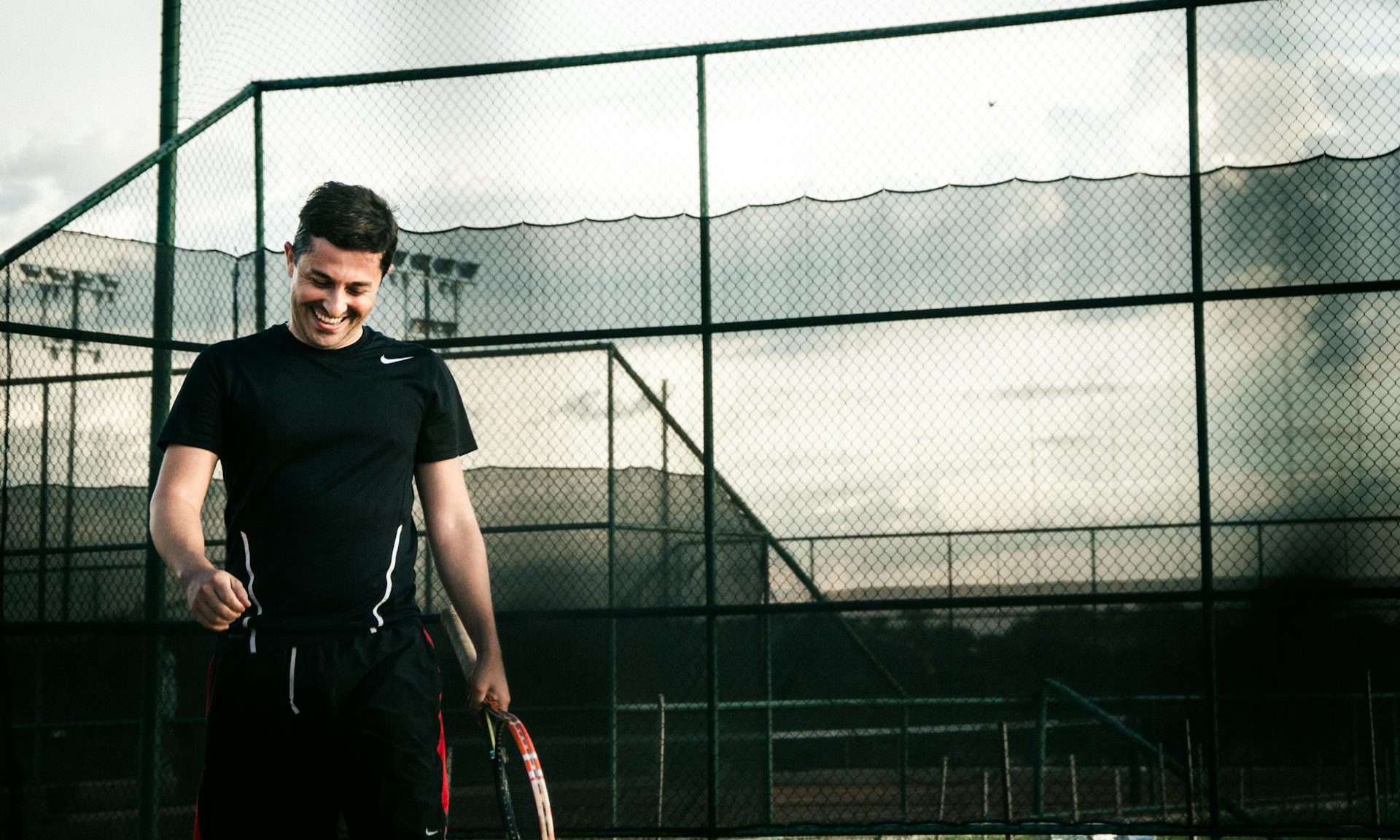 Hombre feliz jugando al tenis