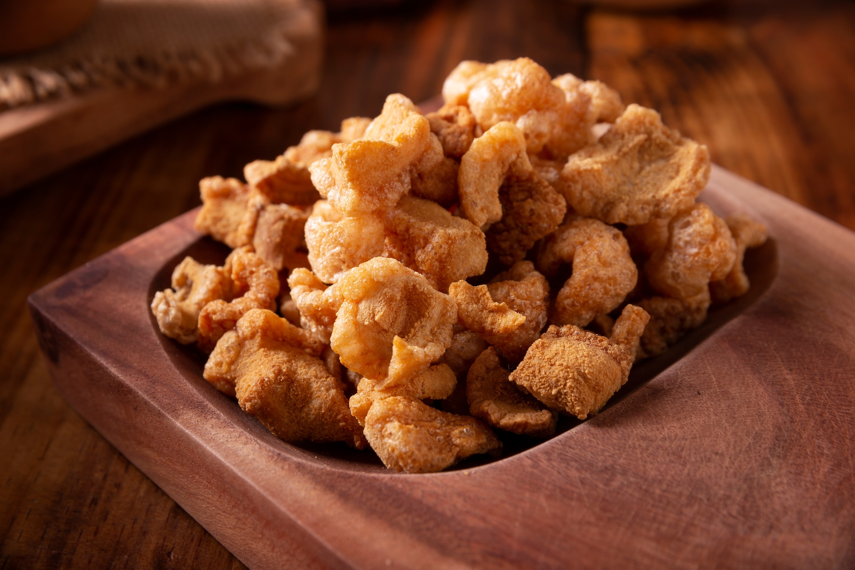 Chicharrones. Piel de cerdo frita, trozos crujientes de cerdo, ingrediente o aperitivo tradicional mexicano servido con jugo de limón y salsa roja picante.
